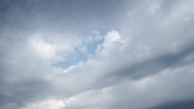 Mavi gökyüzünde güzel beyaz ve karanlık fırtına bulutları. Ses ölçüsü etkisi. Troposferde koruma. Zaman atlaması. Kümülüs bulutları düşük seviyeli, kabarık, pamuk gibi. Yumuşak Cumulonimbus. Yağmurlu korkunç bulutlar.