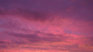 Pembe gün batımı gökyüzü bulutları. Leylak ve menekşenin yumuşak soğuk tonu dingin ve güzel bir atmosfer oluşturur. Batan güneşin yumuşak ışınları ufku boyuyor. Dramatik gün batımı. Gerçek zamanlı, kümülüs bulutları.