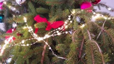 Parlak kırmızı ve gümüş toplarla süslenmiş canlı bir Noel ağacı, parlak çelenkler ve şenlikli kurdeleler, yeni yıl mevsiminde sıcacık bir ortamda bayram neşesi yayıyor. Neşeli kış havası