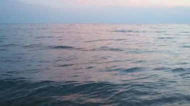 Güneş ufukta batarken sakin güzelliği gözlemleyin. Okyanusta yumuşak renkler bırakın. Yumuşak dalgalar barışçıl bir şekilde dalgalanır, yansımayı davet eden sakin bir atmosfer yaratır. Akdeniz Adriyatik Denizi.