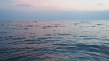 Güneş ufukta batarken sakin güzelliği gözlemleyin. Okyanusta yumuşak renkler bırakın. Yumuşak dalgalar barışçıl bir şekilde dalgalanır, yansımayı davet eden sakin bir atmosfer yaratır. Akdeniz Adriyatik Denizi