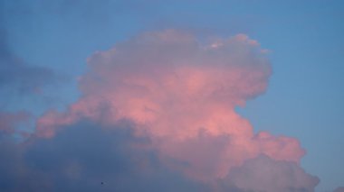 Göz kamaştırıcı pembe bir akşam bulutu alacakaranlık gökyüzünde zarafetle belirir, dingin bir parıltı yayar. Bu büyüleyici görüntü, huzurlu bir akşamın özünü yansıtıyor. Yansıma ve merak uyandırıyor..