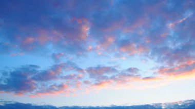 Pastel renklerin büyüleyici bir görüntüsü, gün ışığından geceye geçerken gökyüzünü boyuyor. Yumuşak bulutlar yavaşça sürükleniyor, solan güneş tarafından aydınlatılıyor, sakin bir atmosfer yaratıyor. Gerçek zamanlı.