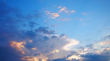 Canlı sarı, turuncu, gri ve mavi bulutların akşam gökyüzünde dans ederek ruhu büyüleyen sakin ve büyüleyici bir atmosfer yarattıkları nefes kesici günbatımının güzelliğini deneyimleyin..