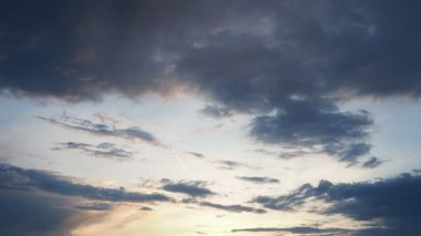 Gündüz geceye dönerken gökyüzünün büyüleyici dönüşümüne tanık olun. Yumuşak altın ışık, karanlık bulutlarla harmanlanarak dinamik ve dinamik bir atmosfer yaratır. Huzurlu bir an yaşanıyor.