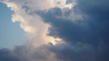 Gökyüzünde güzel beyaz bulutlar. Ses ötesi ışık efekti. Güneş ışınları yaklaşan kara bulutların arkasında gizlidir. Troposferde kümülüs konveksiyon. Cumulonimbus Günbatımı ve gün batımı. Zaman aşımı.