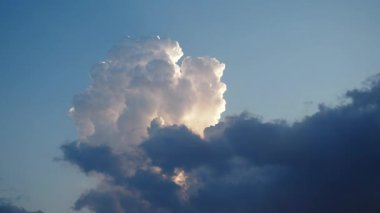 Canlı bir gökyüzü, gün batımının ılık renkleriyle yıkanmış tüylü beyaz bulutları sergiliyor, ufuk boyunca sakin bir ortam yaratıyor, rahatlama ve tefekkür için mükemmel. Zaman aşımı. Akşam şafağı.