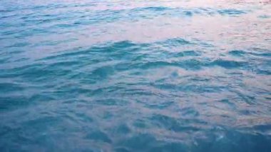 Karadağ 'ın Canj plajında güzel bir sabahın dinginliğini hissedin. Hafif dalgalar kumlu kıyıya vurur, gün doğarken gökyüzünün yumuşak renklerini yansıtır..