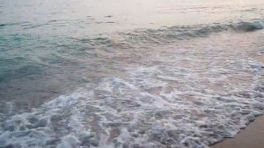 Karadağ 'ın Canj kentindeki kumlu plajda sakin bir sabah yaşanıyor. Dalgalar Adriyatik Denizi kıyısında yavaşça kırılarak barışçıl bir atmosfer yaratıyor. Sersemletici su, sabah ışığını yansıtır..