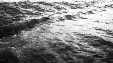 Karadağ 'da Canj' ın kumlu sahillerine sabah güneşi yumuşak bir parıltı saçarken hafif dalgalar çarpıyor. Huzurlu Akdeniz manzarası rahatlama ve barışı davet ediyor. Siyah-beyaz tek renkli yüksek kontrastlı.