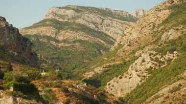 Karadağ 'daki Stari Bar' ın nefes kesici yaz güzelliğini tecrübe edin. Bereketli yeşillik, berrak bir gökyüzünün altında görkemli dağlarla buluşur. Huzurlu manzaraları ve bölgenin canlı doğasını gözler önüne serer..