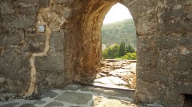 Karadağ 'ın Stari Bar kentindeki antik kale duvarına kazınmış çarpıcı embriyoya bakın. Bu eşsiz pencere, eski kasabanın zengin tarihine ve nefes kesici manzarasına bir bakış sunuyor..