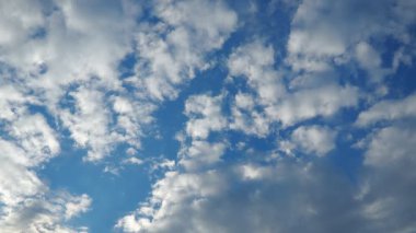 Huzurlu bir öğleden sonra, yumuşak beyaz bulutlarla dolu çarpıcı mavi bir gökyüzünü gözler önüne seriyor. Bu güzel doğal manzara, sakin bir ortamda rahatlamaya ve tefekküre davet ediyor..