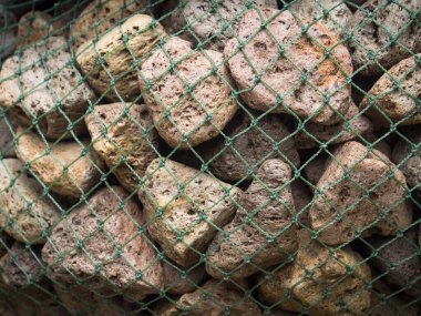Nehir taşları plastik ağ ile kaplıydı, dekoratif tasarım için arka plan yüzeyi..