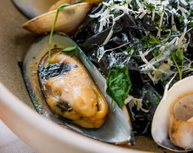 Siyah ahtapot mürekkepli makarna ve peynirli bivanalar, gurme tarzı yemek.