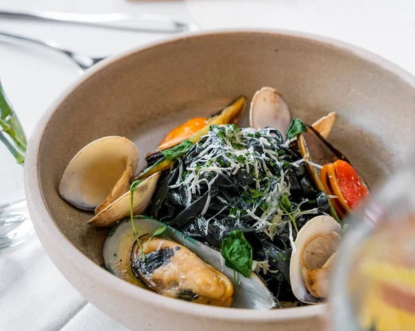 Siyah ahtapot mürekkepli makarna ve peynirli bivanalar, gurme tarzı yemek.