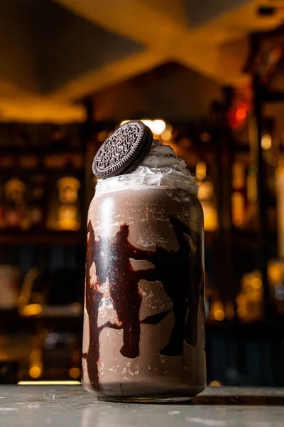 Delicious and fresh coffee frappe with dark chocolate and chocolate cookie, served in a transparent crystal glass, in a bar of an exclusive coffee shop.