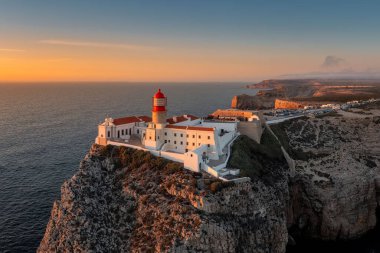 Günbatımında deniz feneri olan Portekiz kıyıları, gün batımında Cabo De Sao Vincente