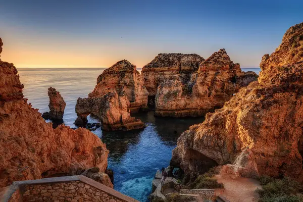 Lagos, Miradouro da Ponta da Piedade gün batımında, Portekiz kıyılarında batan güneş ışınlarında bir deniz feneri