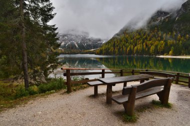 Dolomitler 'de göl, Lago di Braies sonbaharda sisli ve yansımalı.