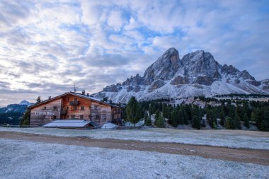 Utia de Borz hut in Passo Erbe after sunrise at the mountain Peitlerkofel, or Sass de Putia clipart