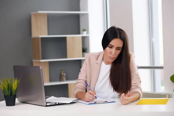 stock image Young female content manager makes notes with a pen.