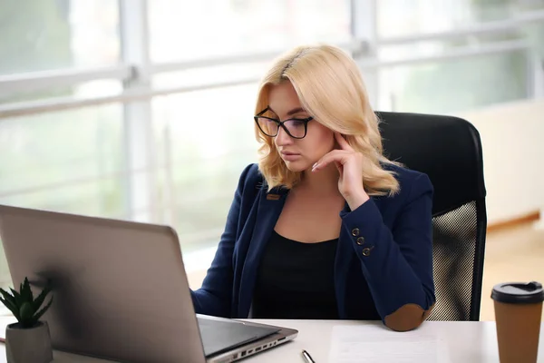 stock image Young businesswoman in the office. Beautiful businesswoman working on her laptop.