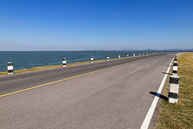 Milestones,black and white milestones roadside with blue sky ,lake roadside in background,concept for next step.go o