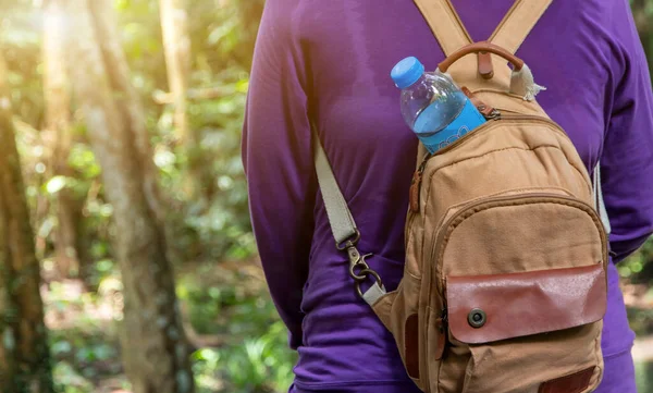 Drinking water bottle in women\'s backpack. Drinking water for hiking, traveling, daily activities