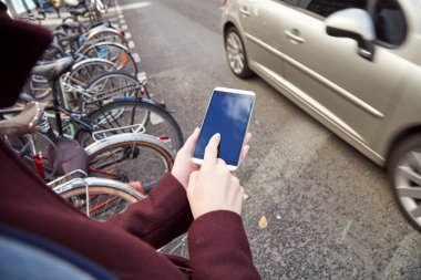 Pedestrian using cellphone while crossing the street.