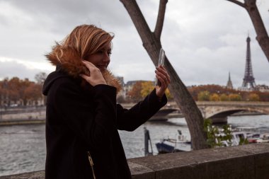Young lady using smartphone on Paris streets.