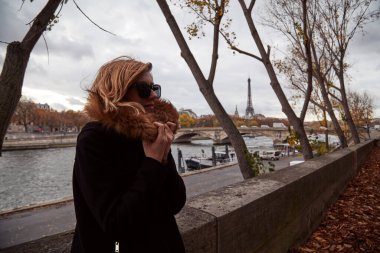 Young lady using smartphone on Paris streets.