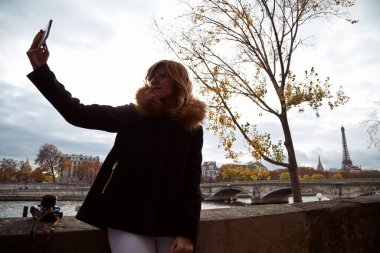 Young lady using smartphone on Paris streets.