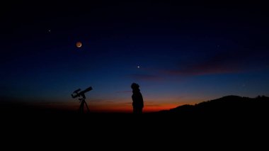 Astronomi teleskopu olan adam gece gökyüzüne, yıldızlara, gezegenlere, aya ve kayan yıldızlara bakıyor..