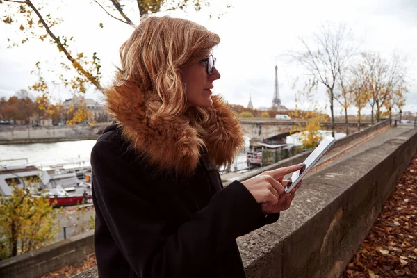 Young lady using smartphone on Paris streets.