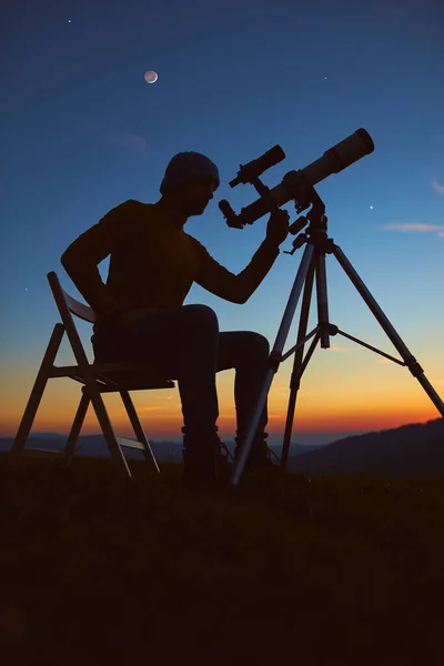 拿着天文望远镜观察夜空 月亮和流星的人 — 图库照片