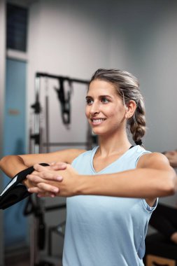 Young women exercising in a gym on pilates machine.