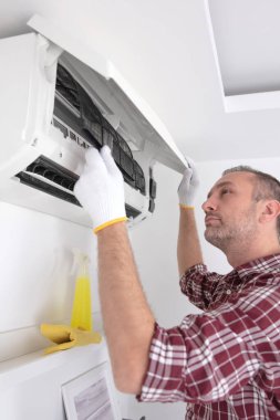 Servis elemanı havalandırmayı temizliyor..