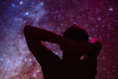 Samanyolu yıldızlı gökyüzüne sahip bir adamın silueti.