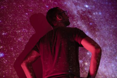 Samanyolu yıldızlı gökyüzüne sahip bir adamın silueti.