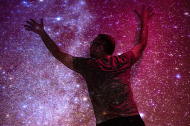 Samanyolu yıldızlı gökyüzüne sahip bir adamın silueti.