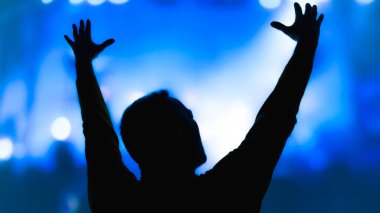 Sahne ışıkları olan bir adamın silueti.