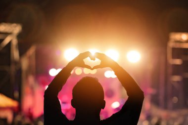 Sahne ışıkları olan bir adamın silueti.