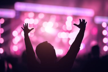 Sahne ışıkları olan bir adamın silueti.