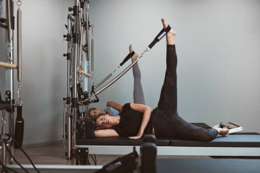 Genç kadın bir spor salonunda egzersiz.