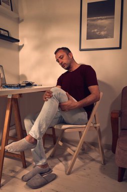 Dizi, bacağı ve eklem ağrısı olan bir adam..