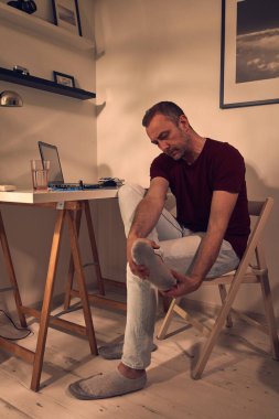 Ayak bileği ve ayak ağrısı olan bir adam..