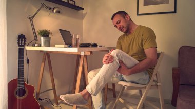 Dizi, bacağı ve eklem ağrısı olan bir adam..