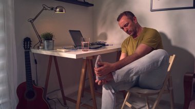 Ayak bileği ve ayak ağrısı olan bir adam..