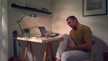 Dizi, bacağı ve eklem ağrısı olan bir adam..